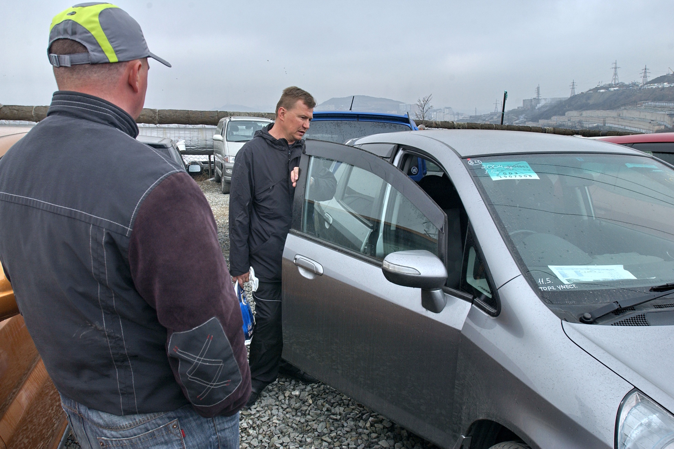 Владивосток. Покупатель во время осмотра автомобиля, выставленного на продажу. 2008 год