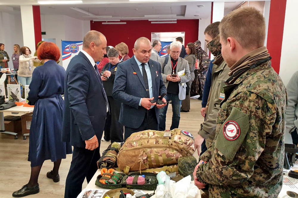 Герой России Рустам Сайфуллин осматривает продукцию, выставленную волонтерами.