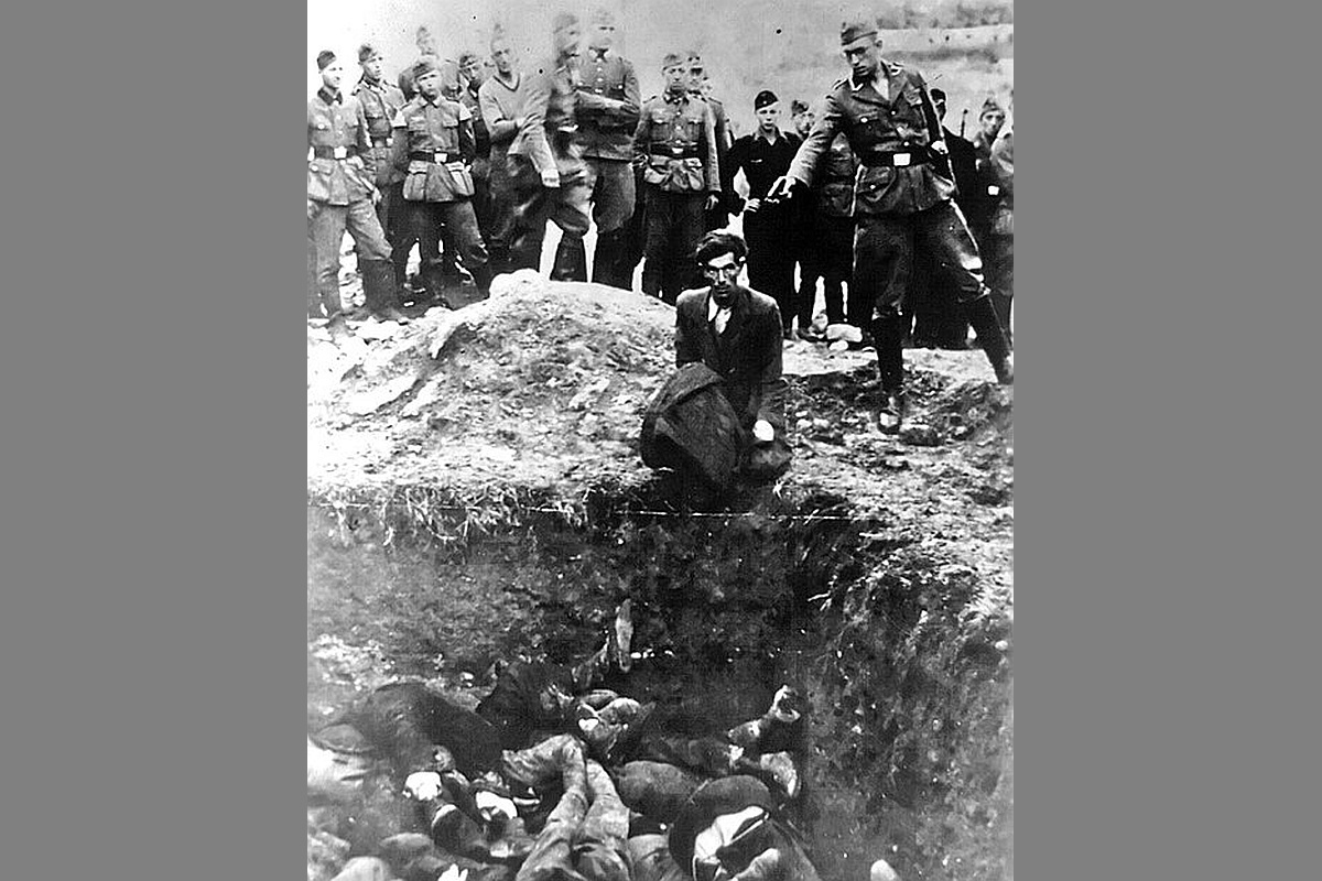 Обреченный человек у ямы, где уже трупы расстрелянных и эсэсовец с пистолетом в руке. Имя палача стало известно лишь спустя 80 лет.