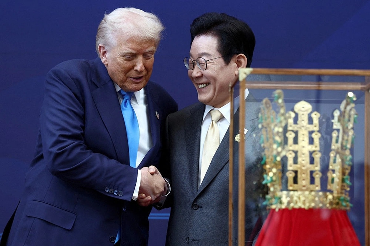 Президент США Дональд Трамп и президент Южной Кореи Ли Джэ Мён жмут руки на фоне копии золотой короны периода Силла. Президент США Дональд Трамп и президент Южной Кореи Ли Джэ Мён жмут руки на фоне копии золотой короны периода Силла.