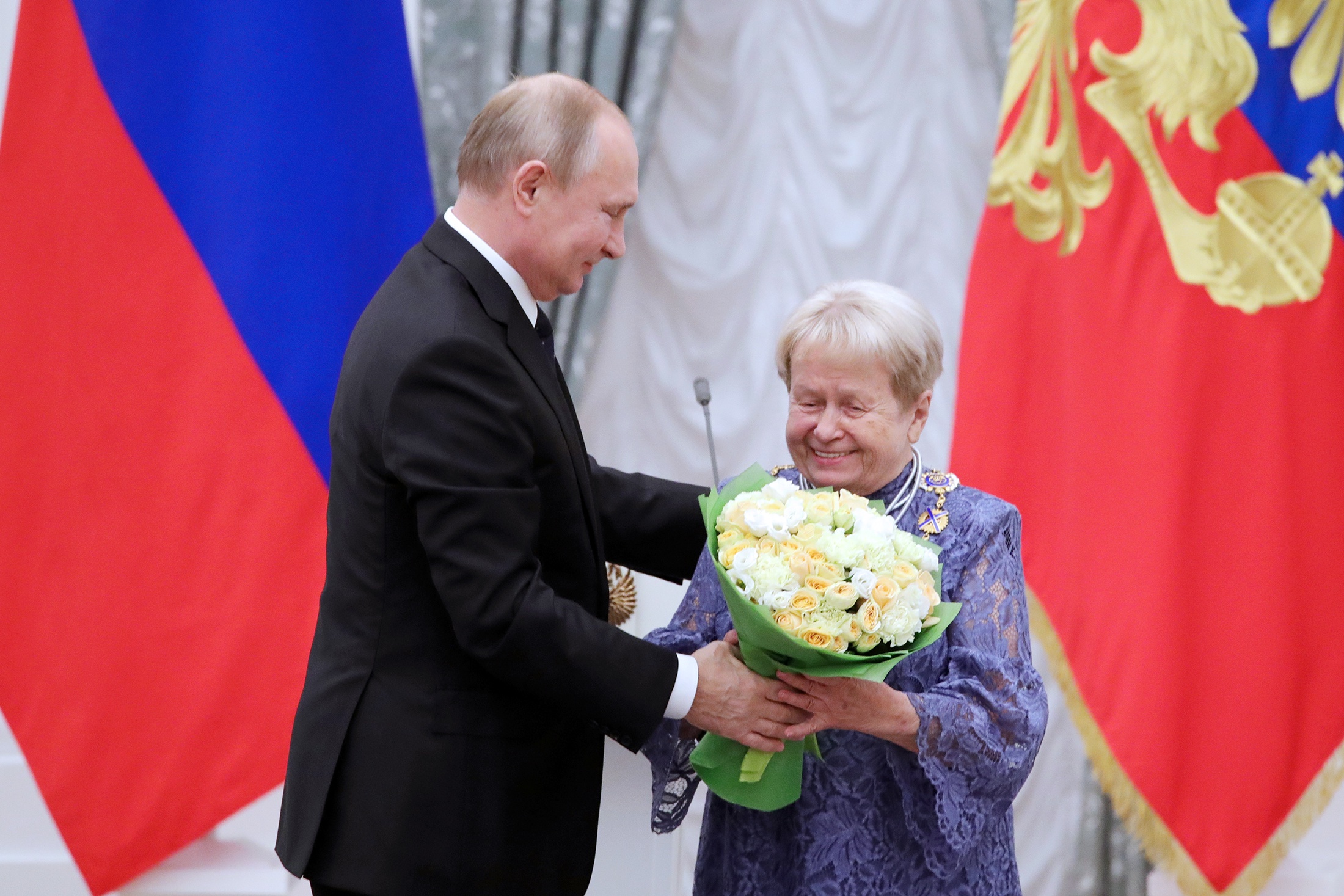 Владимир Путин и Народная артистка СССР, композитор Александра Пахмутова, получившая Орден Святого апостола Андрея Первозванного, на церемонии вручения государственных наград за выдающиеся достижения в области культуры, медицины, спорта, производства в Екатерининском зале Кремля. 2019 год.