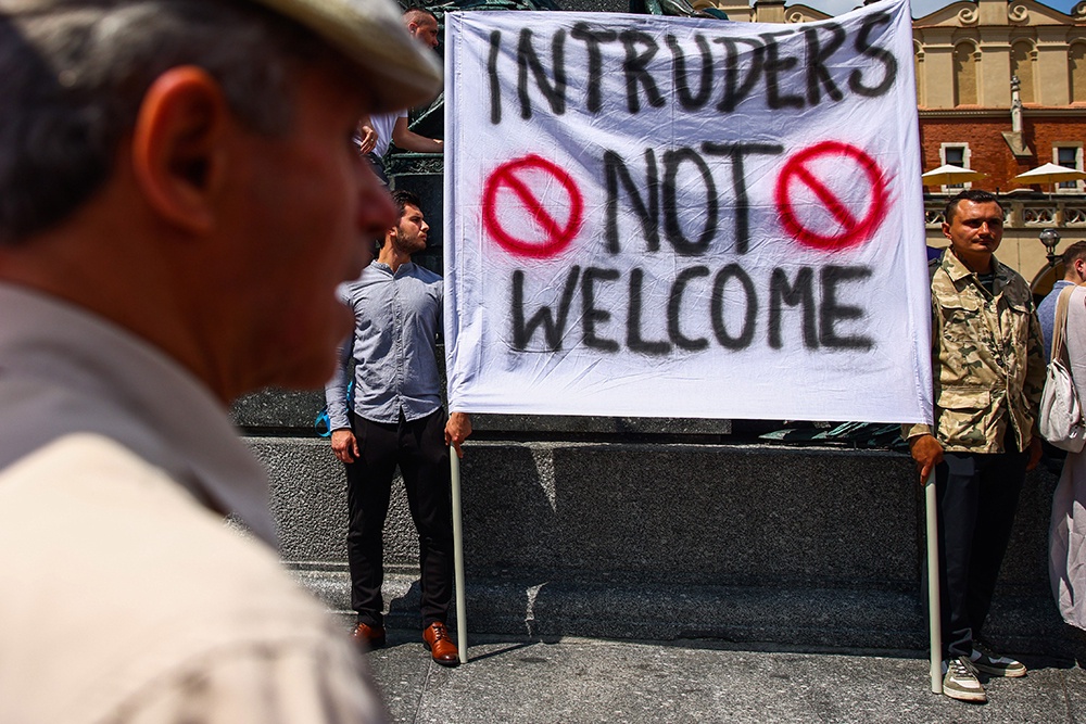 Плакат "Незваным гостям здесь не рады" на митинге в Польше. Запад хочет избавиться от беженцев с Украины.