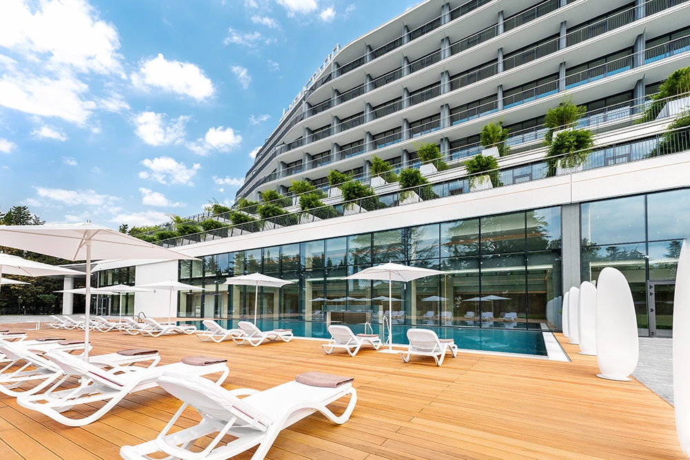 Терраса санатория с открытым бассейном. Внутри здания - другой бассейн, доступный для купания круглогодично.