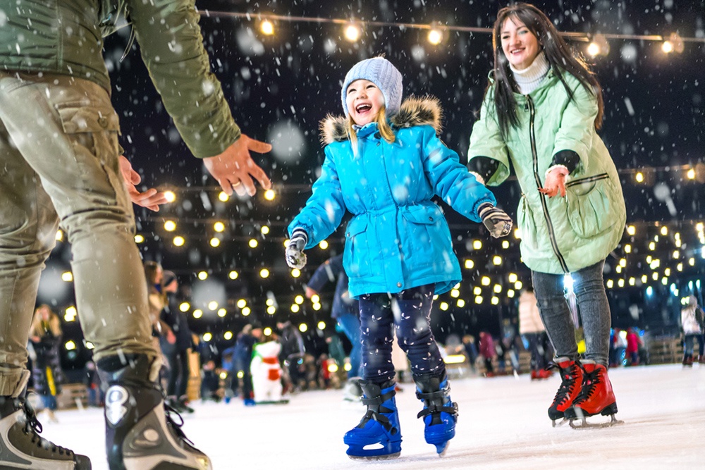 Семья катается на катке в новогодние каникуля