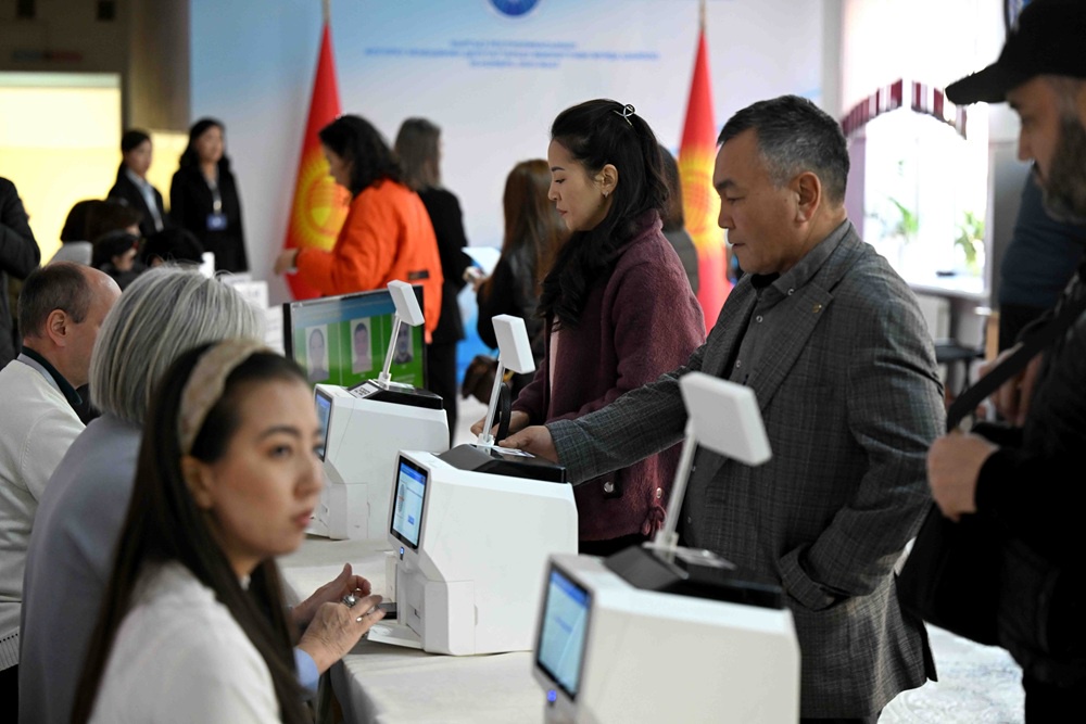 Кыргызские избиратели проходят биометрическую идентификацию перед голосованием.