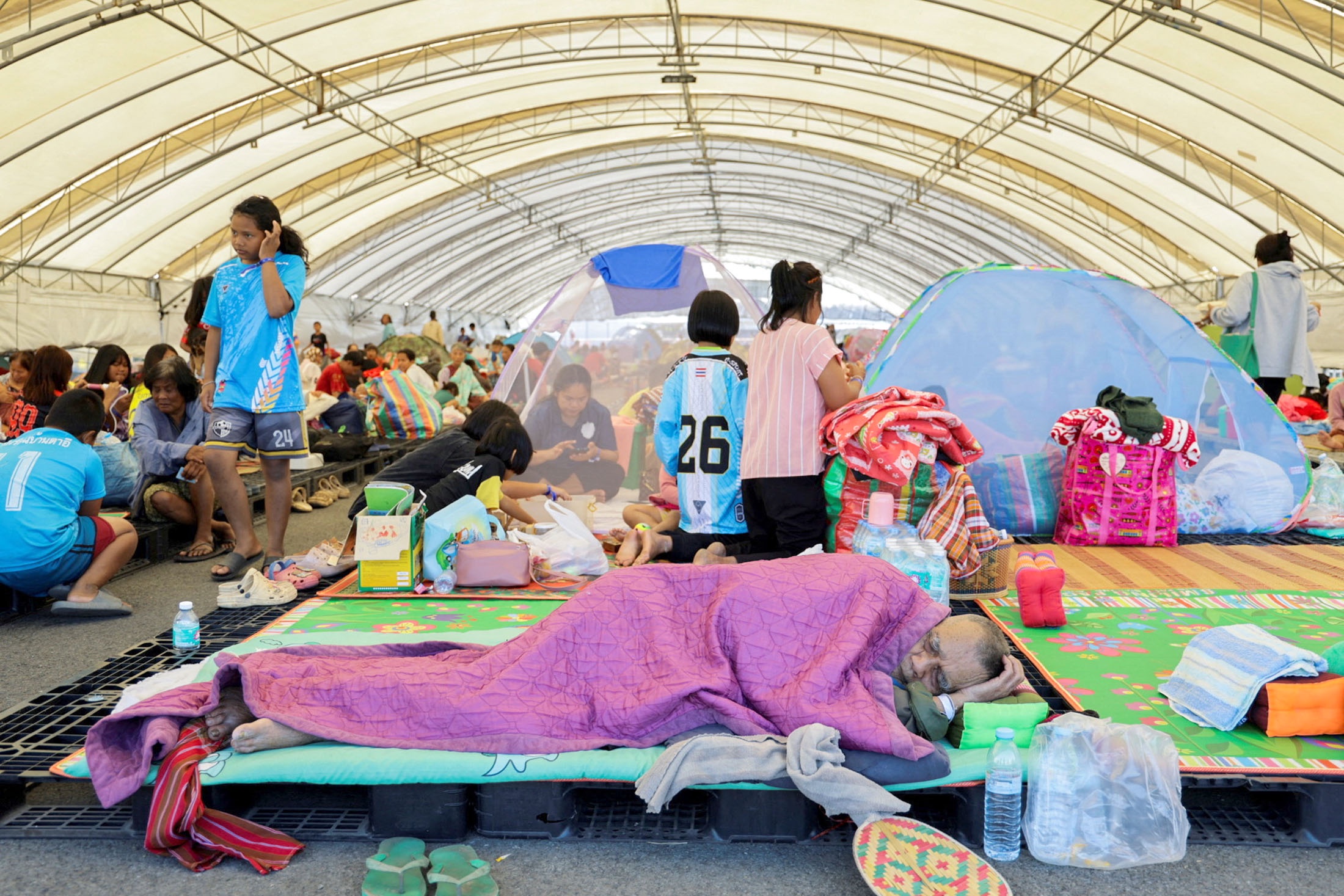 Люди отдыхают в убежище после новых военных столкновений между Таиландом и Камбоджей вдоль участков их спорной границы в провинции Бурирам. Люди отдыхают в убежище после новых военных столкновений между Таиландом и Камбоджей вдоль участков их спорной границы в провинции Бурирам.