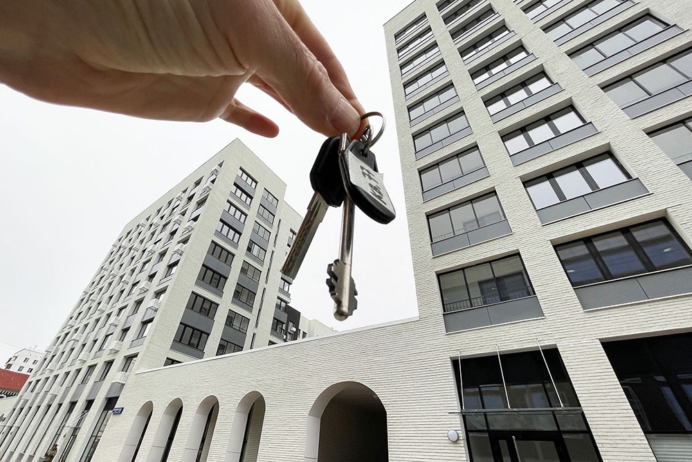 Рука держит ключи от квартиры в новостройке