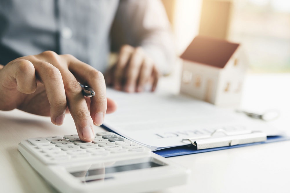 Мужчина на калькуляторе делает расчеты