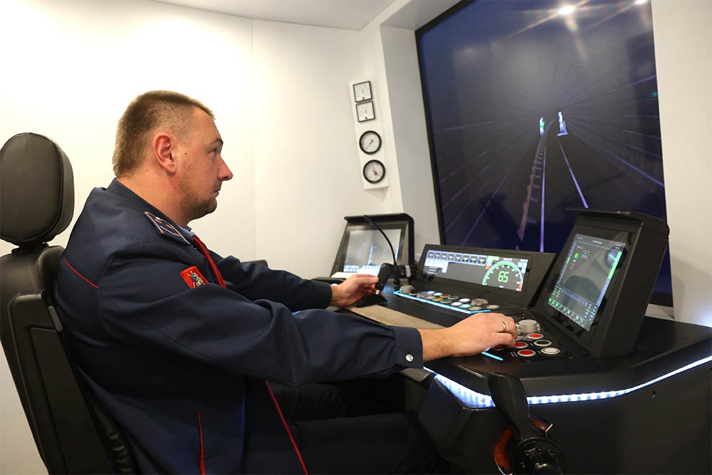 Машинист за тренажером, который в точности повторяет настоящую кабину поезда "Москва-2024".
