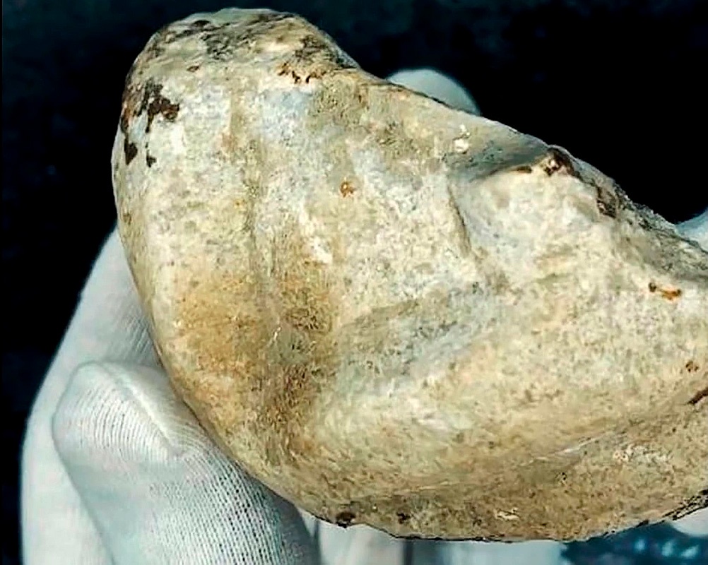 На фрагменте видны остатки резного орнамента, похожие на ремни обуви. Возможно, это была статуя.