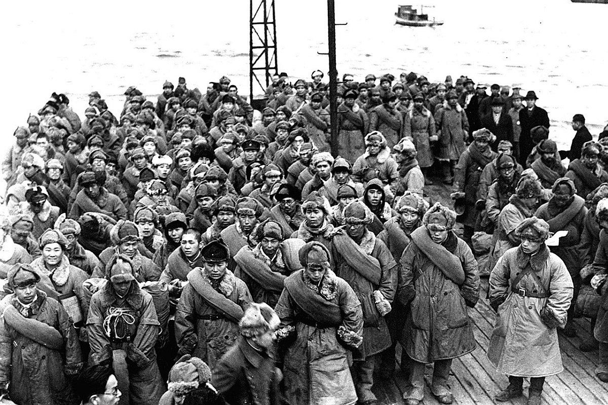 Репатриированные японские солдаты, возвращающиеся из Сибири, ждут, чтобы сойти с корабля на берег. Майдзуру, префектура Киото, Япония, 1946 год.