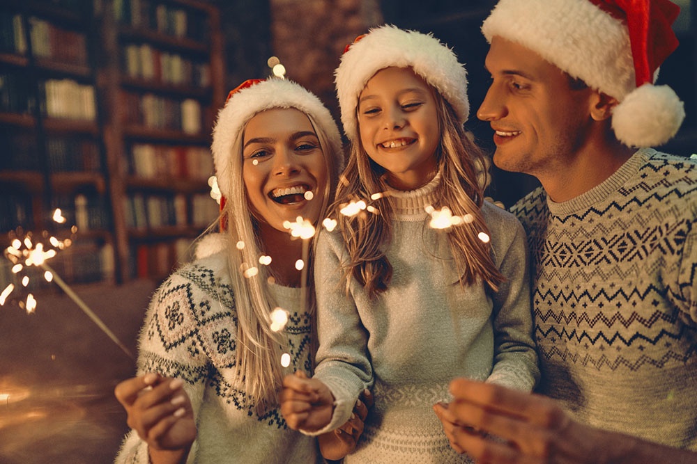 Семья с бенгальскими огнями на новогоднем празднике