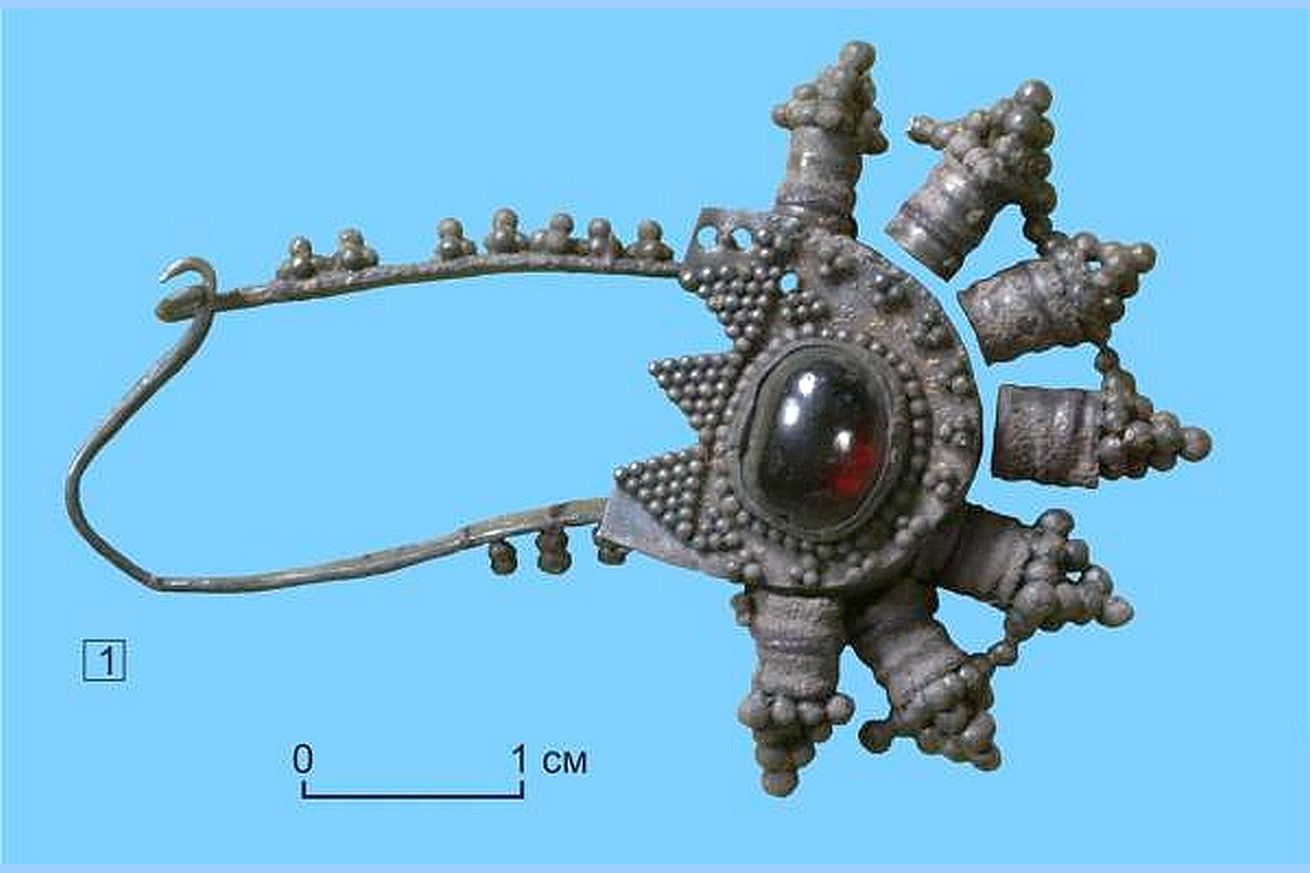 Серебряная подвеска-фибула с гранатом не только подчеркивает высокий социальный статус, но и говорит об отношении к детству в ту пору.