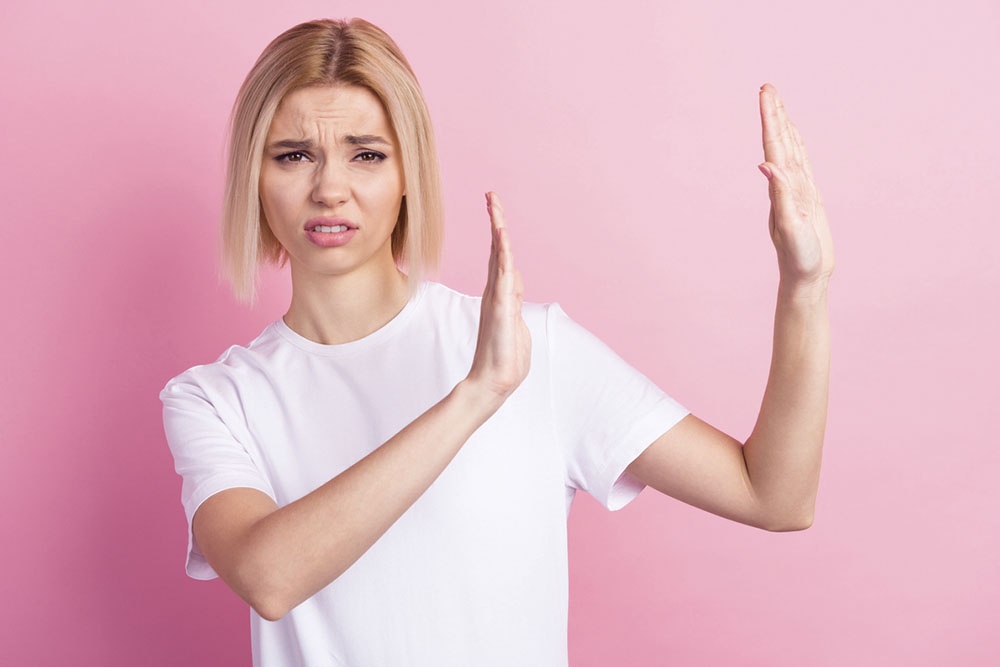 Девушка показывает руками подает знак 
