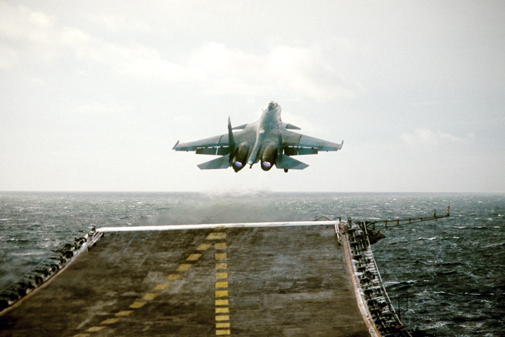 Основное ударное оружие тяжелого авианесущего крейсера "Адмирал Флота Советского Союза Кузнецов" - это истребители-бомбардировщики Су-27К с боевым радиусом около 1100 км.