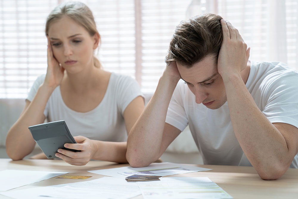 Женщина и мужчина огорчены нехваткой денег в семейном бюджете