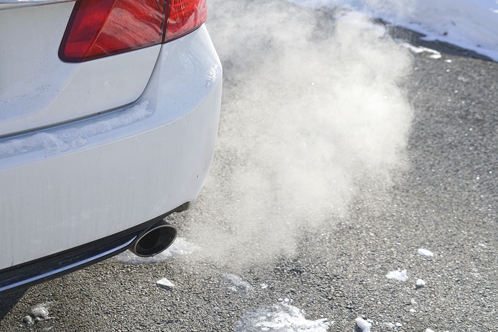 Автомобили в зимнее время прогревается на месте, дым из выхлопной трубы.