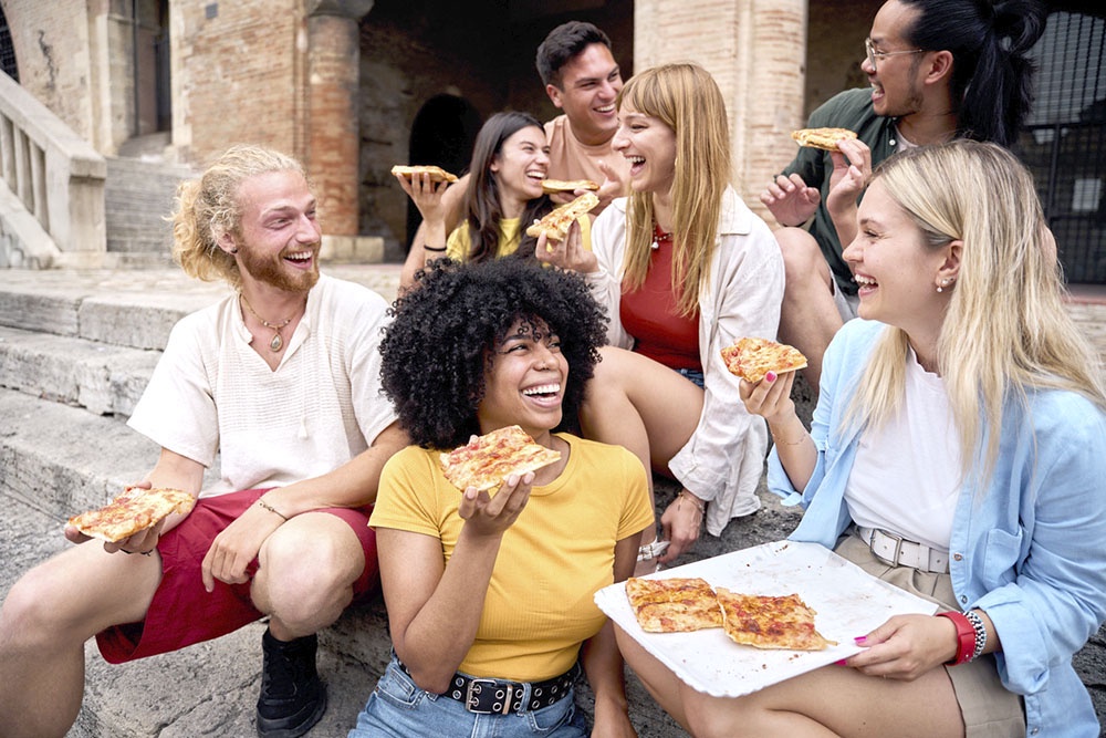 Молодежь из разных стран, собравшаяся вместе за пиццей.