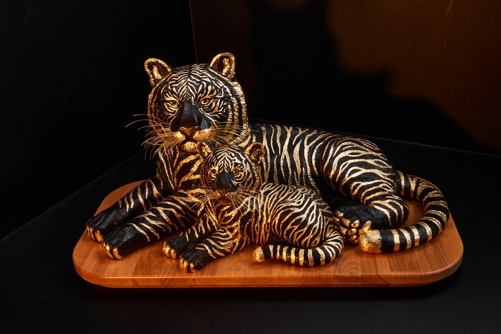 Тигрица с тигренком сделана из темного янтаря. Полоски на их шкуре животных - из золотой потали