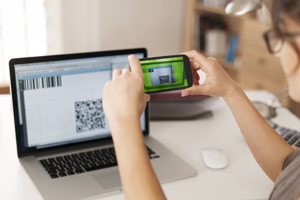 Женщина оплачивает покупку, сканирует QR  код.