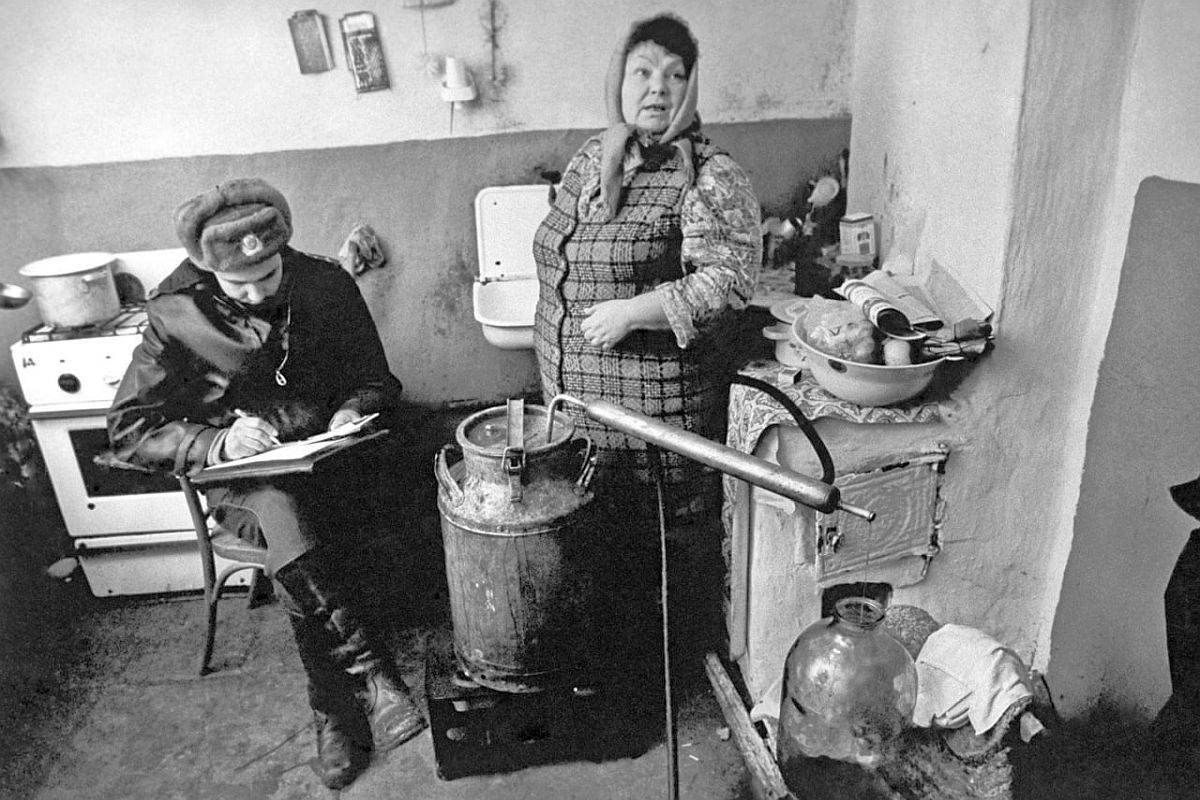 Рейд по борьбе с самогоноварением. На снимке: участковый инспектор составляет протокол в доме самогонщицы. 1987 год. Рейд по борьбе с самогоноварением. На снимке: участковый инспектор составляет протокол в доме самогонщицы. 1987 год.