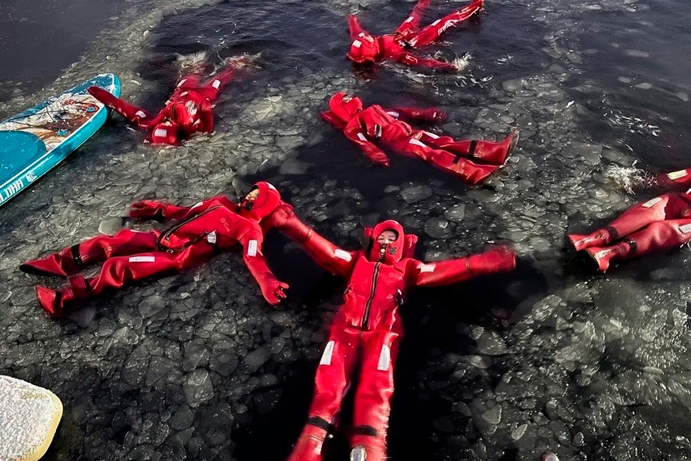 Туристы купаются в ледяной воде, одетые в защитные многослойные гидротермокостюмы.
