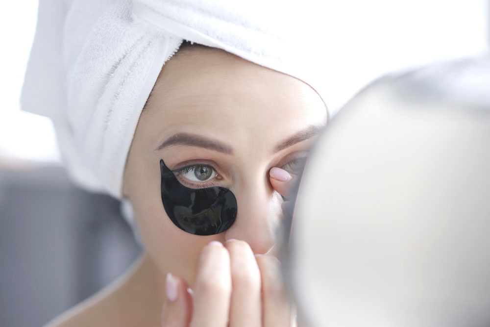 Как быстро убрать мешки под глазами в домашних условиях, изменить привычки, чтобы отеки не портили утро, и отличить временную проблему от симптомов заболеваний. Девушка борется с мешками под глазами.