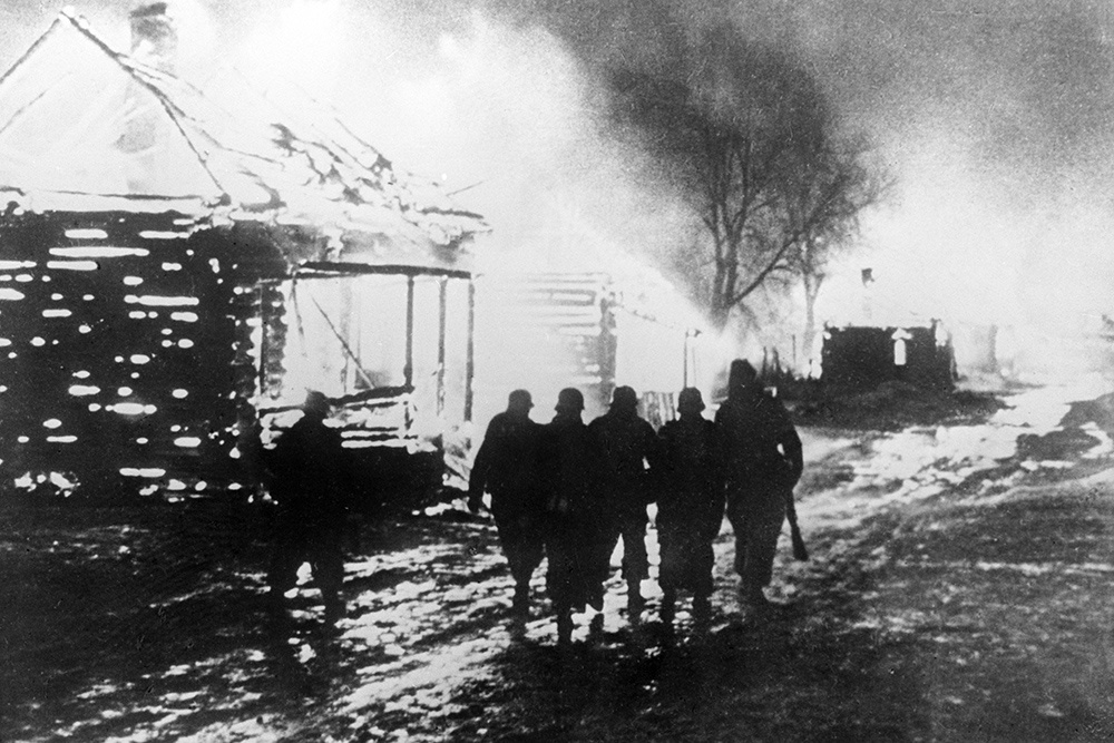 Ушачский район на территории Витебской области в Беларуси. Солдаты СС идут по горящей деревне, в которой они сожгли все дома. Ушачский район на территории Витебской области в Беларуси. Солдаты СС идут по горящей деревне, в которой они сожгли все дома.