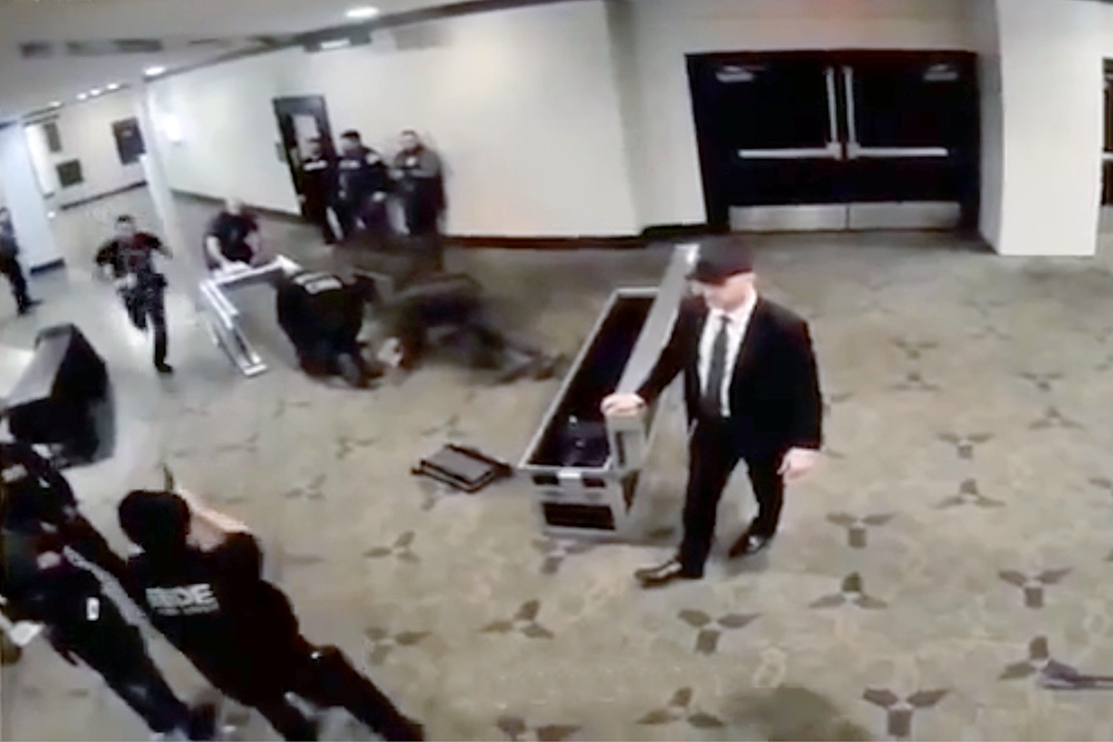 На кадре с камеры видеонаблюдения видно, как нападавший бежит в сторону охранников. В одного из них через секунды он выстрелит.