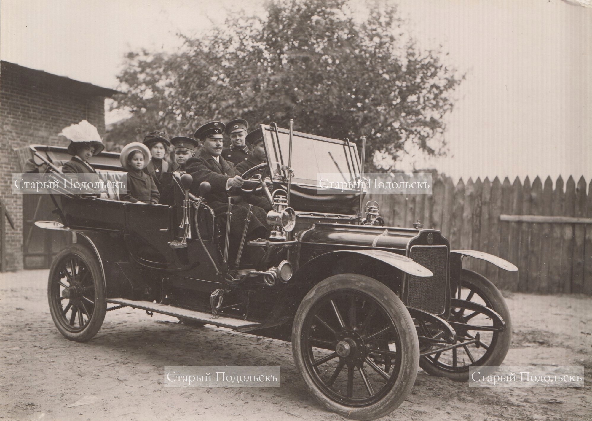 Подольск, 1910 г., с территории Цементного завода выезжает семья Доллежалей, слева направо: Елена Фердинандовна (сестра главного инженера завода); Оля (дочь главного инженера и сестра будущего знаменитого ученого-энергетика); гувернантка семьи (француженка); Володя (сын главного инженера и брат знаменитого ученого-энергетика, сам будущий инженер-конструктор авиационных моторов); Антон Фердинандович (главный инженер Подольского цементного завода); Коля (будущий знаменитый ученый-энергетик); помощник семьи. Это один из первых автомобилей на улицах Подольска. Фотография публикуется впервые. 