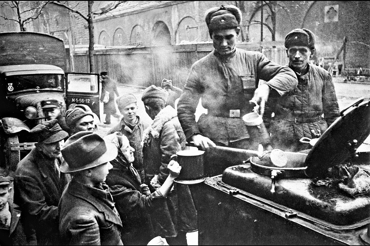 Спустя 80 лет житель Германии с теплотой вспоминает о советских солдатах. На фото: советские солдаты раздают еду жителям Берлина в мае 1945-го.