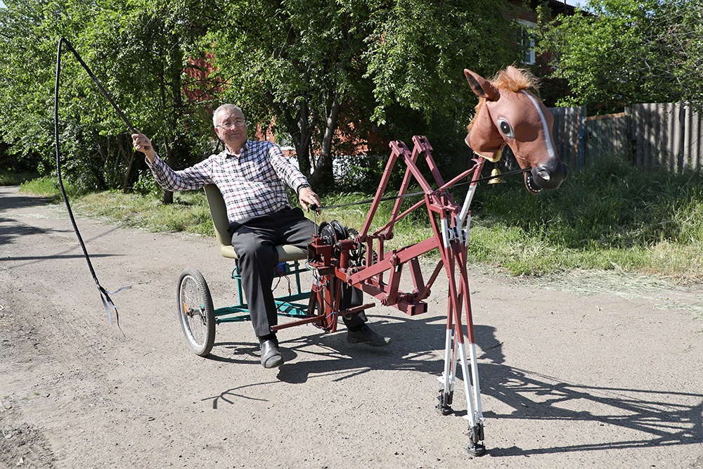 Михаил Иванович ловко управляется с созданным им механическим конем.