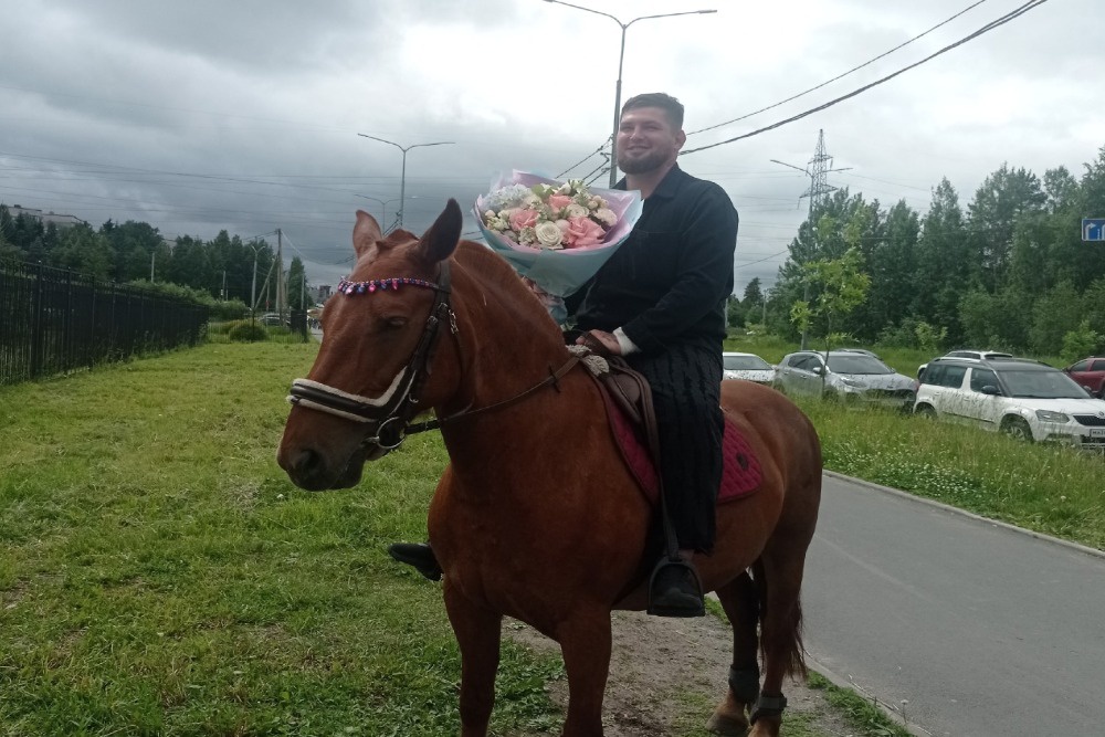 Молодой папа встречает жену с двойней из роддома на лошади.