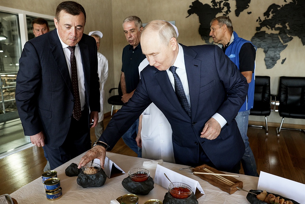 Президент России Владимир Путин решает, какую икру попробовать. Рядом - губернатор Сахалинской области Валерий Лимаренко.
