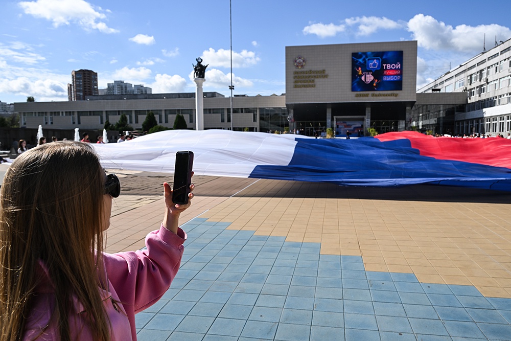 Активисты "Молодой Гвардии Единой России","Волонтерской Роты" и студенты РУДН участвуют в памятной акции ко Дню государственного флага РФ на главной площади Российского университета дружбы народов в Москве.