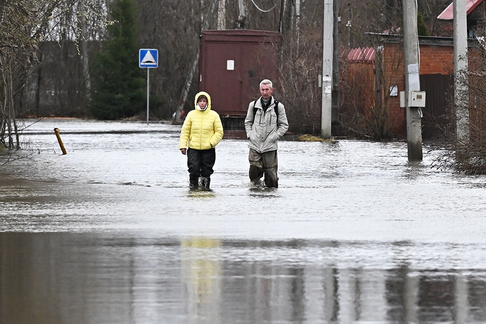 Люди идут по затопленной улице в республике Марий Эл. 