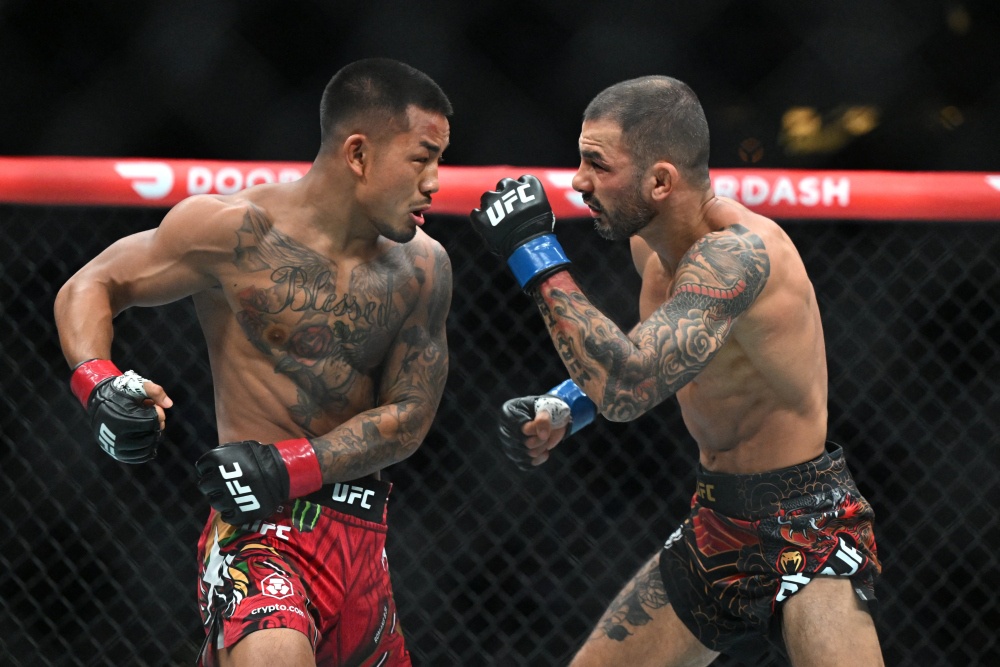 Джошуа Ван (в красных перчатках) и Александр Пантожи во время турнира UFC 331
