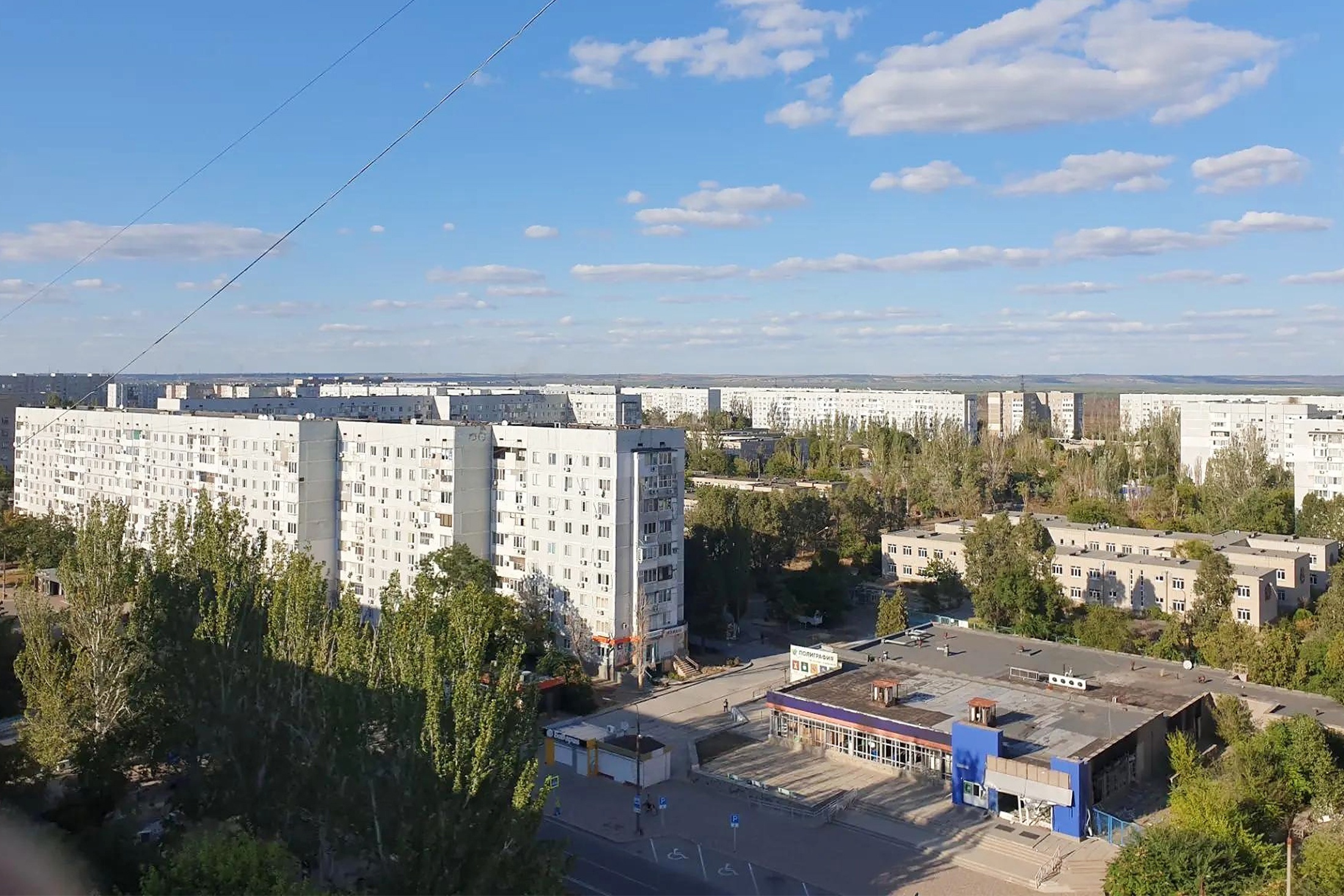 На горизонте за многоэтажками виден украинский берег. До него всего несколько километров через высохшее водохранилище и русло реки Днепр. 