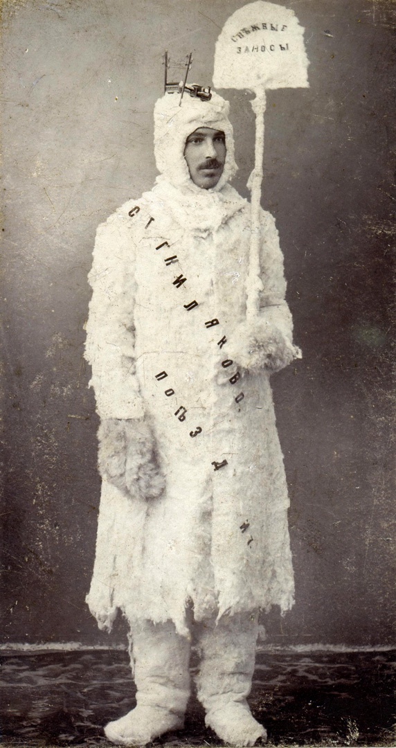 Господин в эксцентрическом костюме "Снежные заносы". На капюшоне - модель поезда № 7 и электрические столбы. 1901 год.