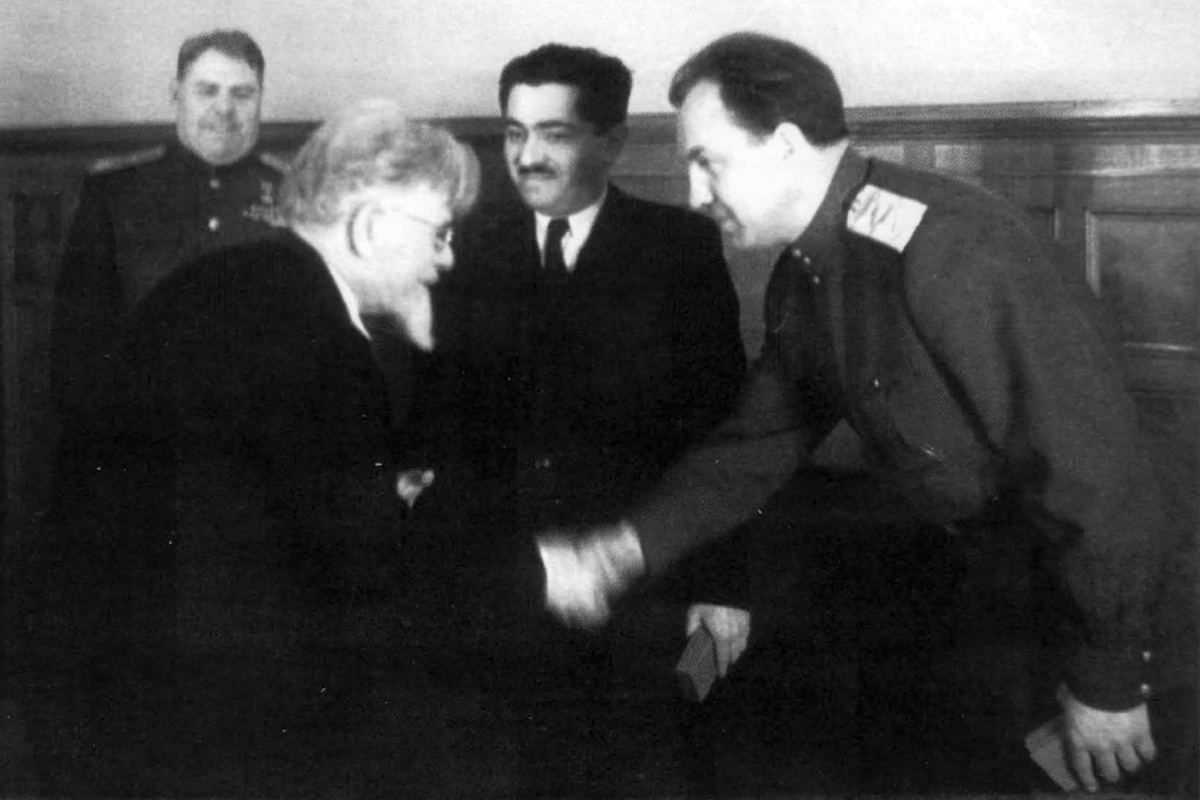 Председатель Президиума Верховного Совета СССР М. И. Калинин вручает орден начальнику ГУКР Смерш, комиссару государственной безопасности 2-го ранга В. С. Абакумову. Среди присутствующих: нарком чёрной металлургии СССР И. Ф. Тевосян, Маршал Советского Союза А. М. Василевский. Москва. 1945 г. Фотограф не установлен.