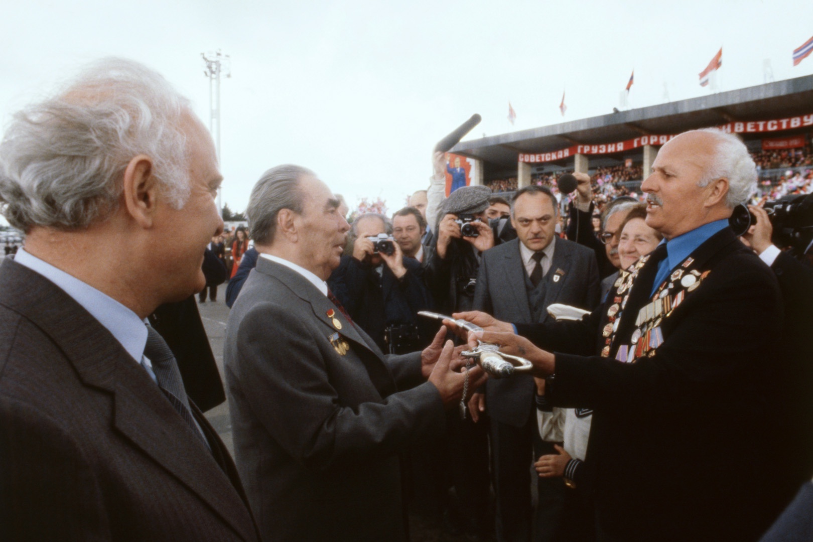 Ветеран Великой Отечественной Войны, директор Мцхетской школы Шалва Татарашвили вручает памятный подарок - оружие - Генеральному секретарю ЦК КПСС Леониду Ильичу Брежневу во время проводов в аэропорту. 