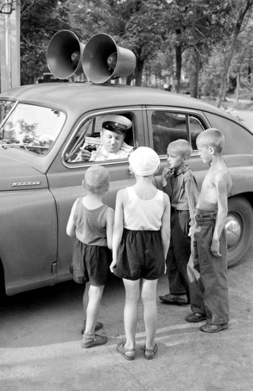 Сотрудник ГАИ разъясняет детям правила дорожного движения. Москва. 1 августа 1956 г. Фотограф не установлен. РГАКФД.